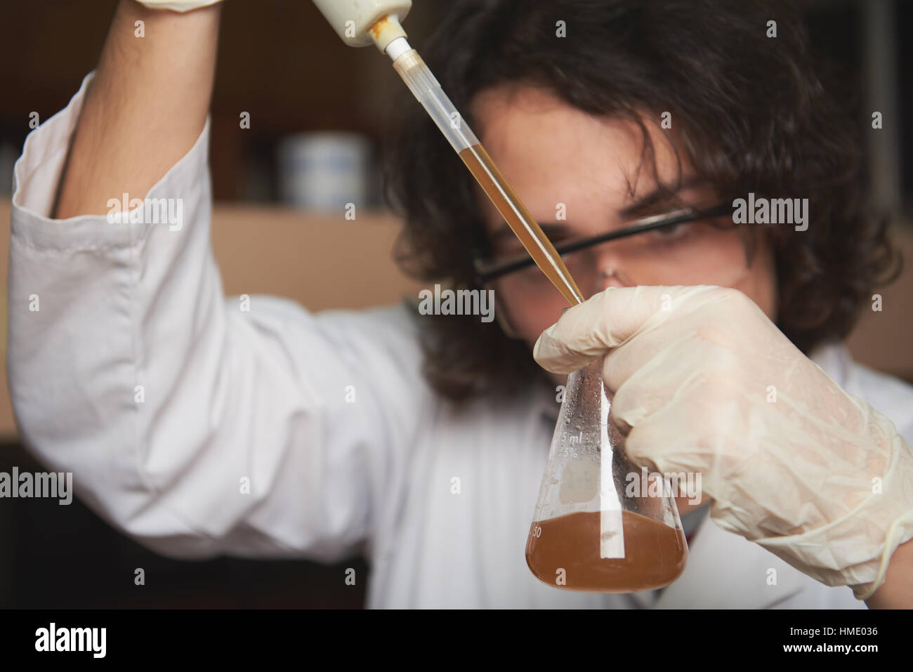 junge Chemiker nehmen Probe von Schmutzwasser im Labor Stockfoto