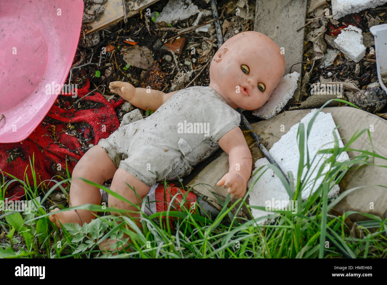 Spielzeugpuppe bleibt ganz allein unter den Müll Stockfoto