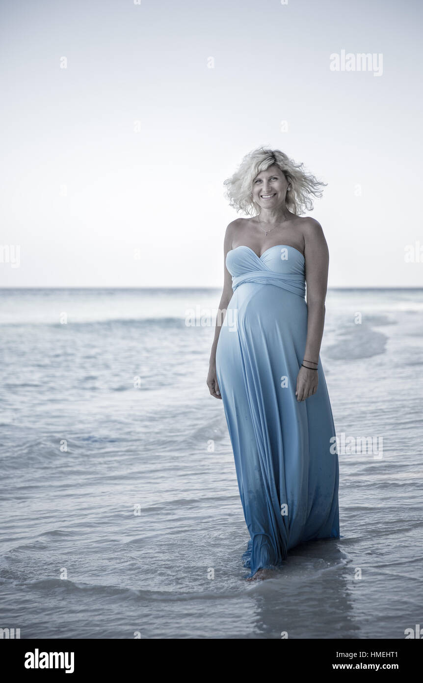 Wundervolle schwangere Frau mit schönen Lächeln ist zu Fuß auf den maledivischen Strand Stockfoto