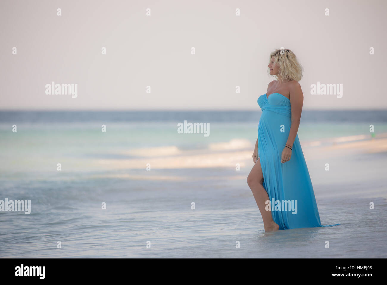 Schöne schwangere Frau steht an der erstaunlichen maledivischen Strand Stockfoto