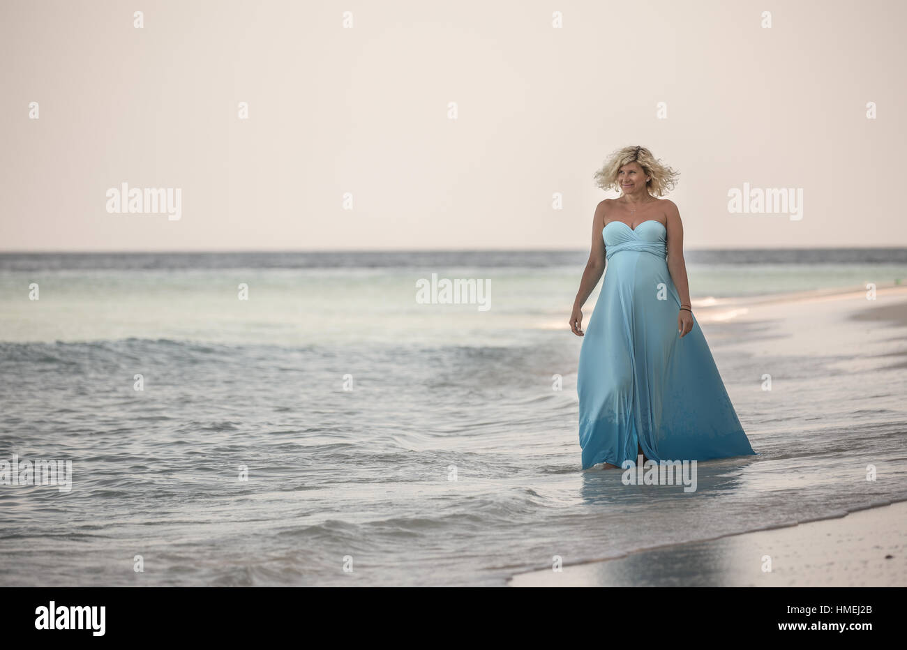 Gerne schwangere Frau ist zu Fuß auf den maledivischen Strand Stockfoto