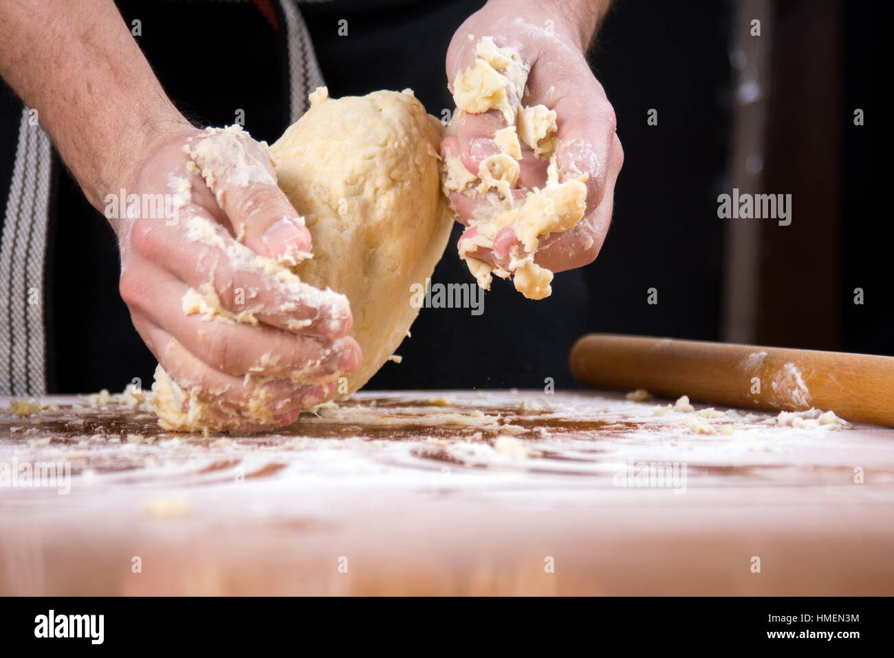 Mann, Kneten von Teig auf einem Tisch Mehl bedeckt Stockfoto