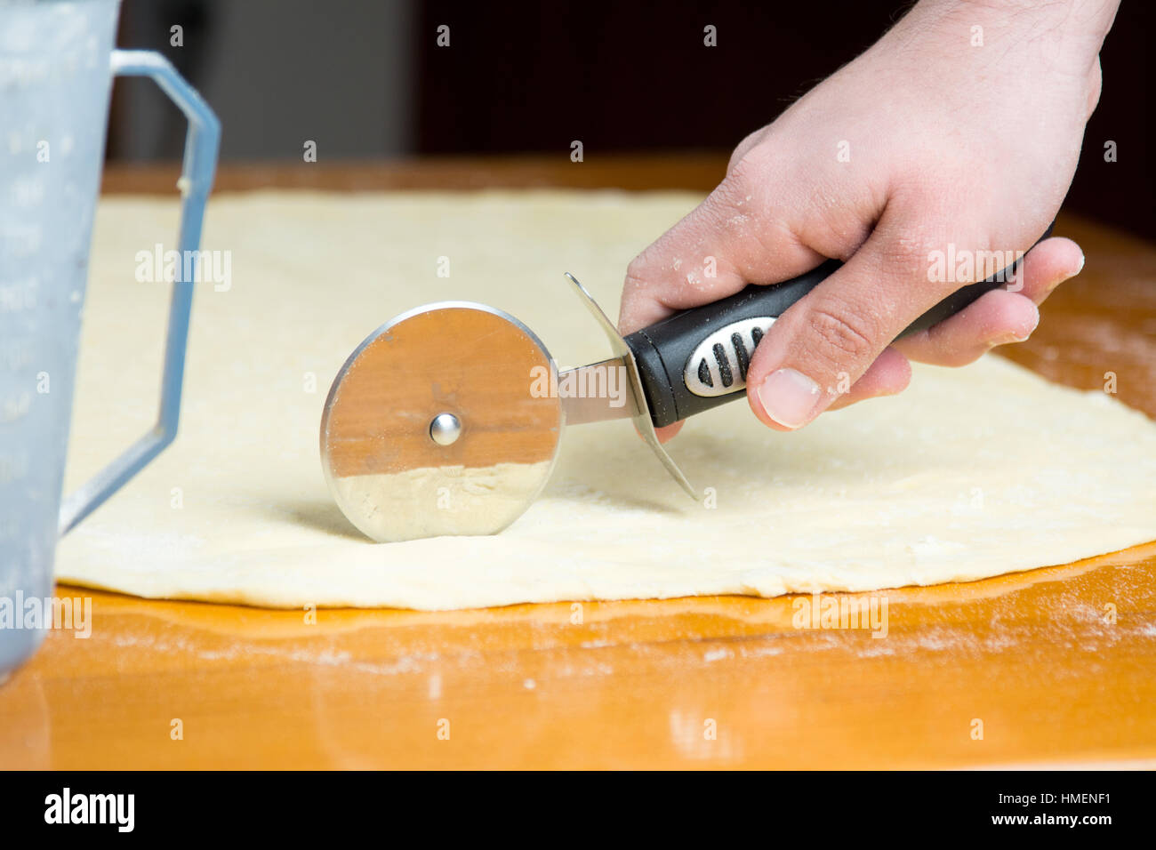 Mann schneiden Teig mit einem Roller-Messer Stockfoto