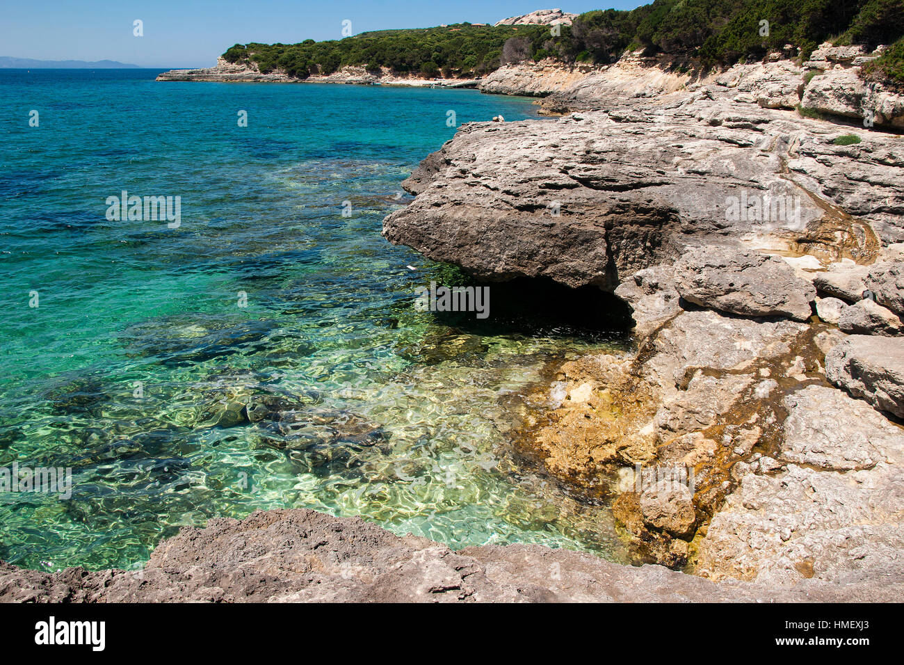 Felsen auf der rechten Seite im Vordergrund mit türkisblauen Meer durch eine einsame Ufer am Capo Testa Sardinien Stockfoto