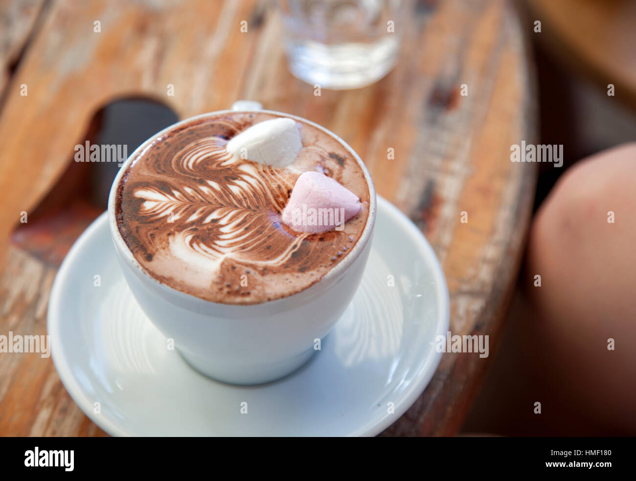 Eine Tasse heiße Schokolade mit Marshmallows auf einem rustikalen Cafétisch Stockfoto