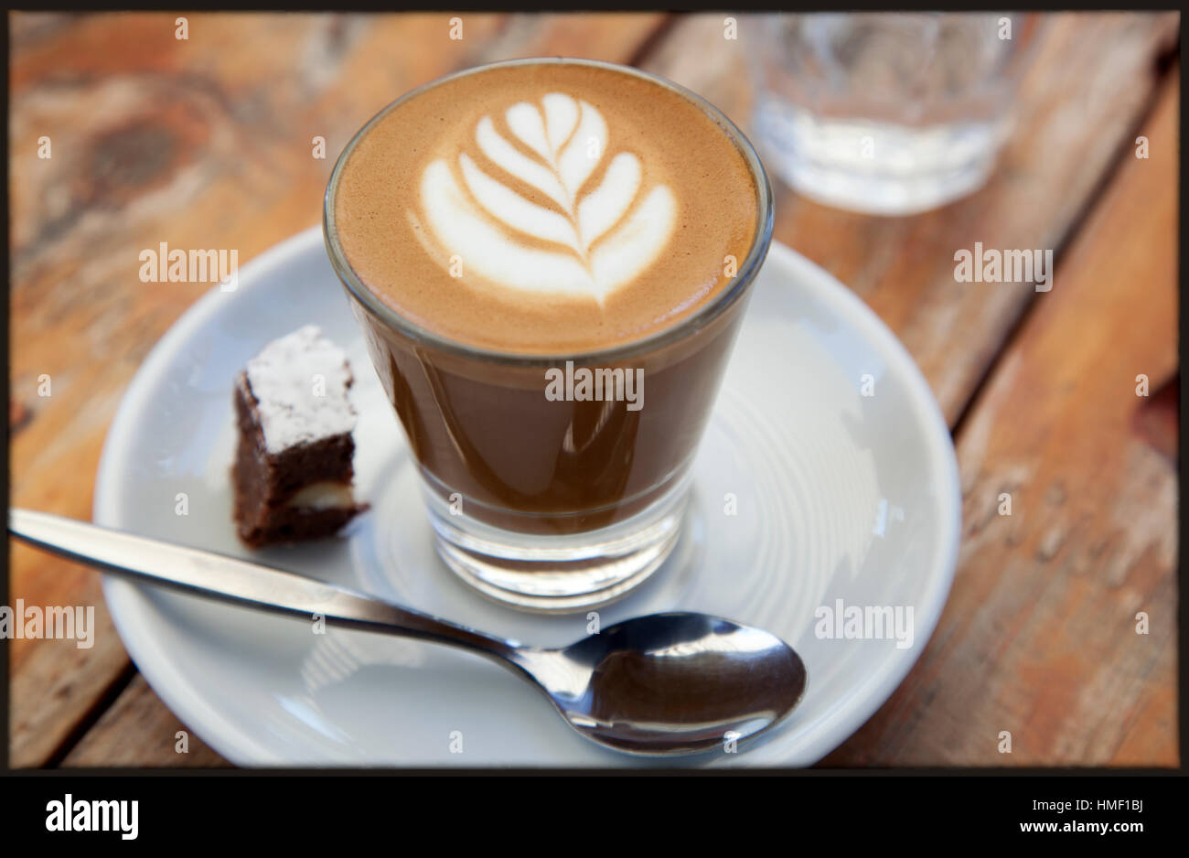 Ein perfekt ausgeführtes Caffe Macchiato und Brownie auf eine Café-Tisch im freien Stockfoto