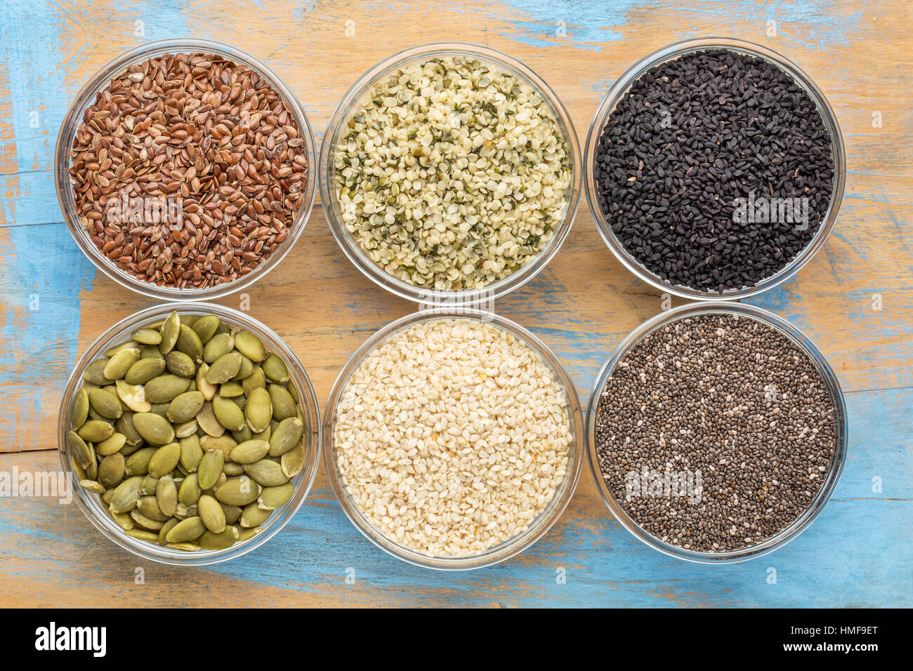 gesundes Saatgut Sammlung (Chia, Hanf-Herzen, braune Flachs, Krbis,  schwarzer Kreuzkmmel, Sesam) - Draufsicht des kleinen Glas Schalen gegen  Grunge Holz Stockfotografie - Alamy