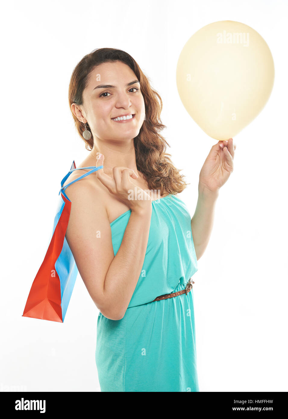 lächelndes Mädchen mit Einkaufstasche und Ballon isoliert auf weiss Stockfoto