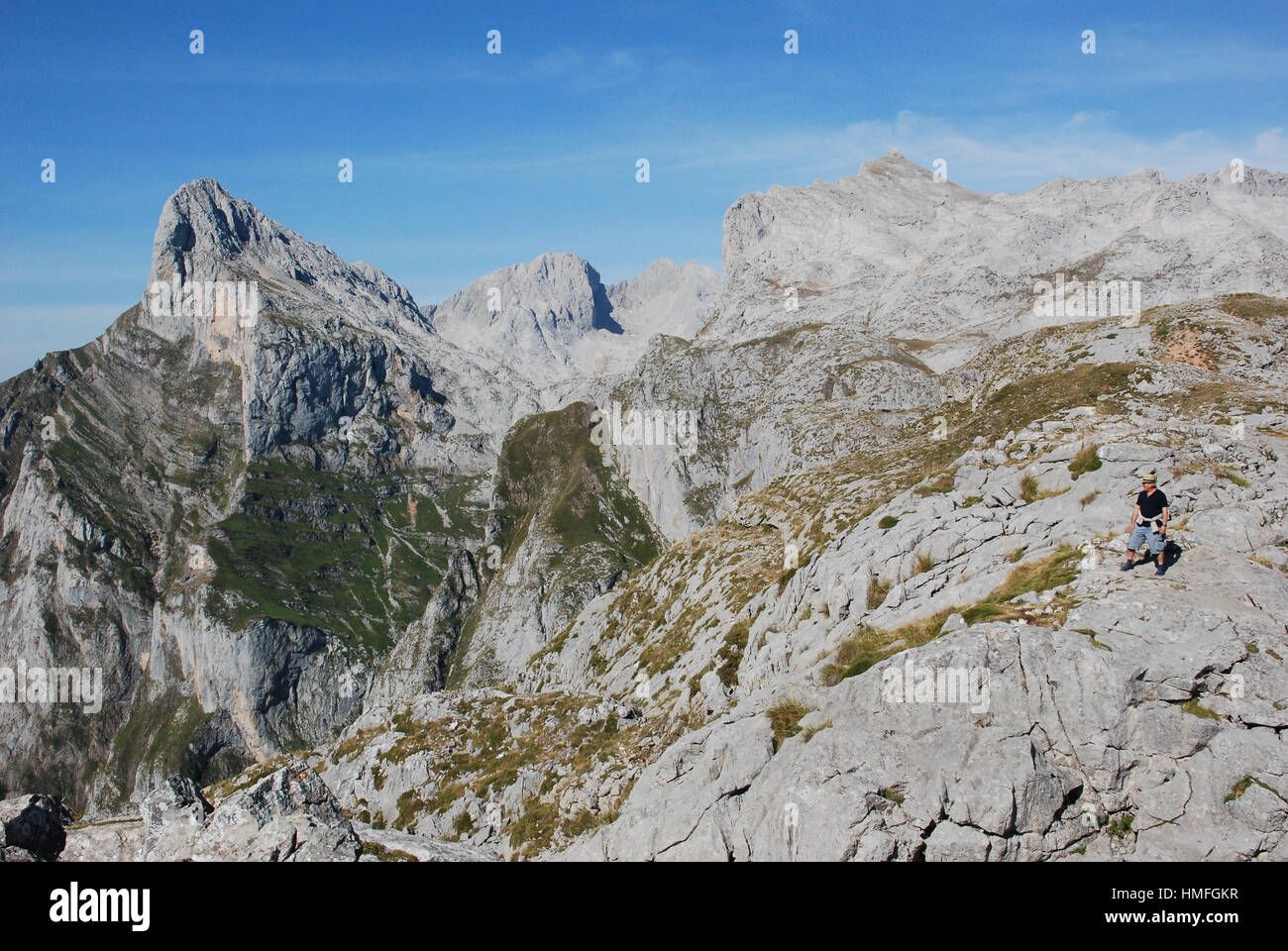 Ein Mann mit einem Strohhut blickt auf den Picos de Europa im Norden Spaniens. Stockfoto