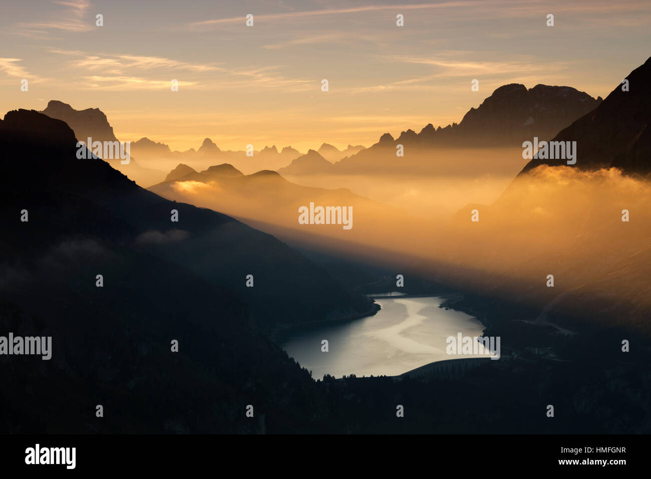 Orange Licht, Strahl und Nebel am Gipfel der Dolomiten und Fedaia Pass, Cima Belvedere, Val di Fassa, Trentino-Alto Adige, Italien Stockfoto