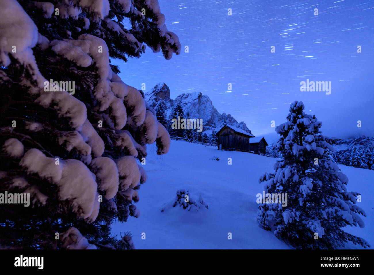 Sternspur und verschneite Bäume umrahmen die Holzhütte und Sass De Peitlerkofels, Passo Delle Erbe, Villnösser Tal, Südtirol, Italien Stockfoto