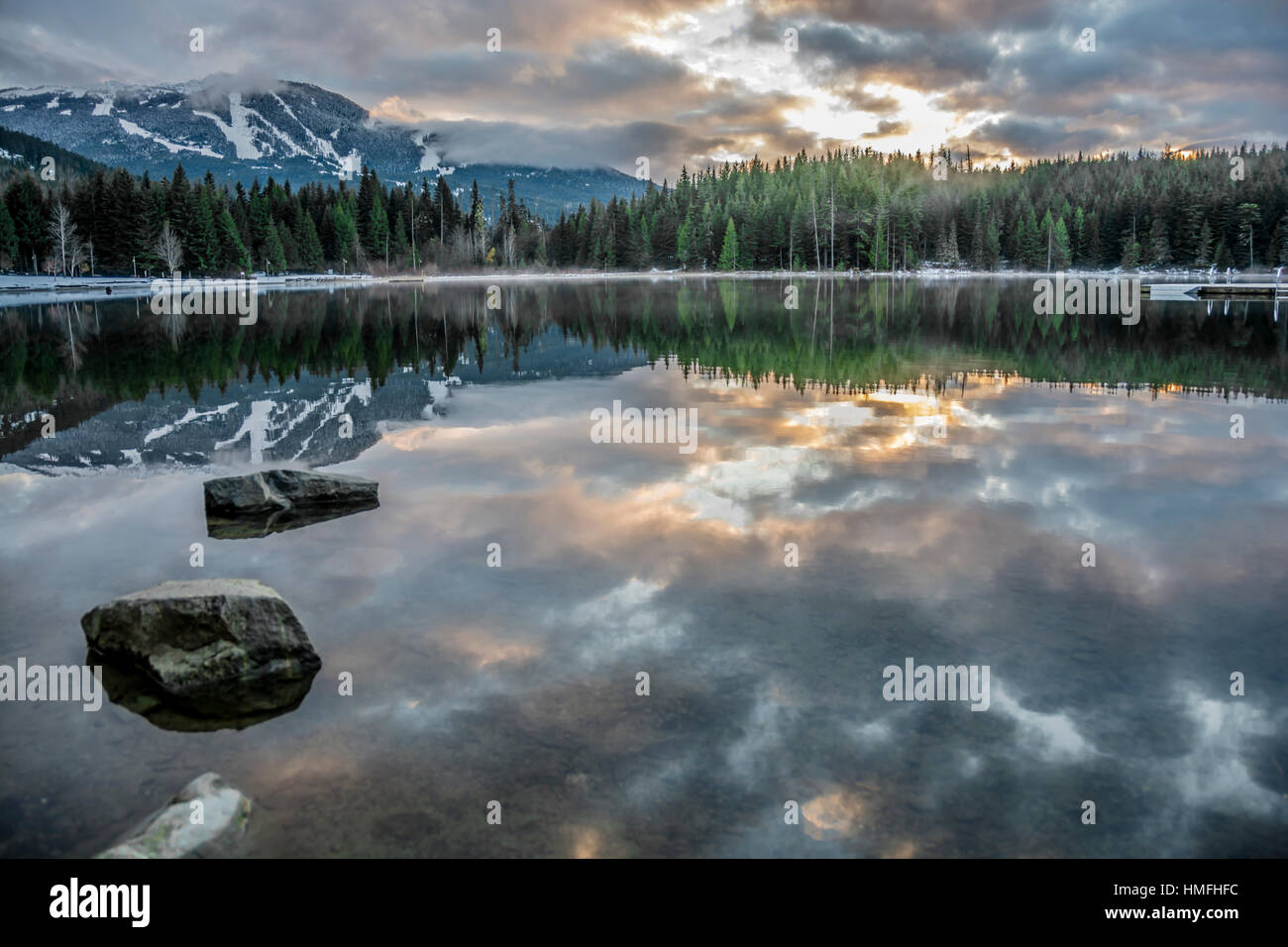 See verloren, es gibt also immer noch ein perfektes Spiegelbild der Sonnenuntergang, Ski-Hügel und umliegenden Wälder, British Columbia, Kanada Stockfoto