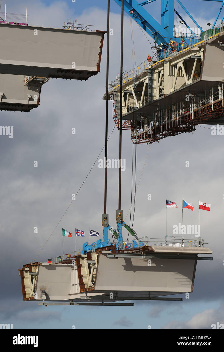 Arbeiter herabblicken, wenn ein Teil der neuen Queensferry Crossing Brücke einrasten von einem Lastkahn in South Queensferry, Edinburgh angehoben wird. Stockfoto