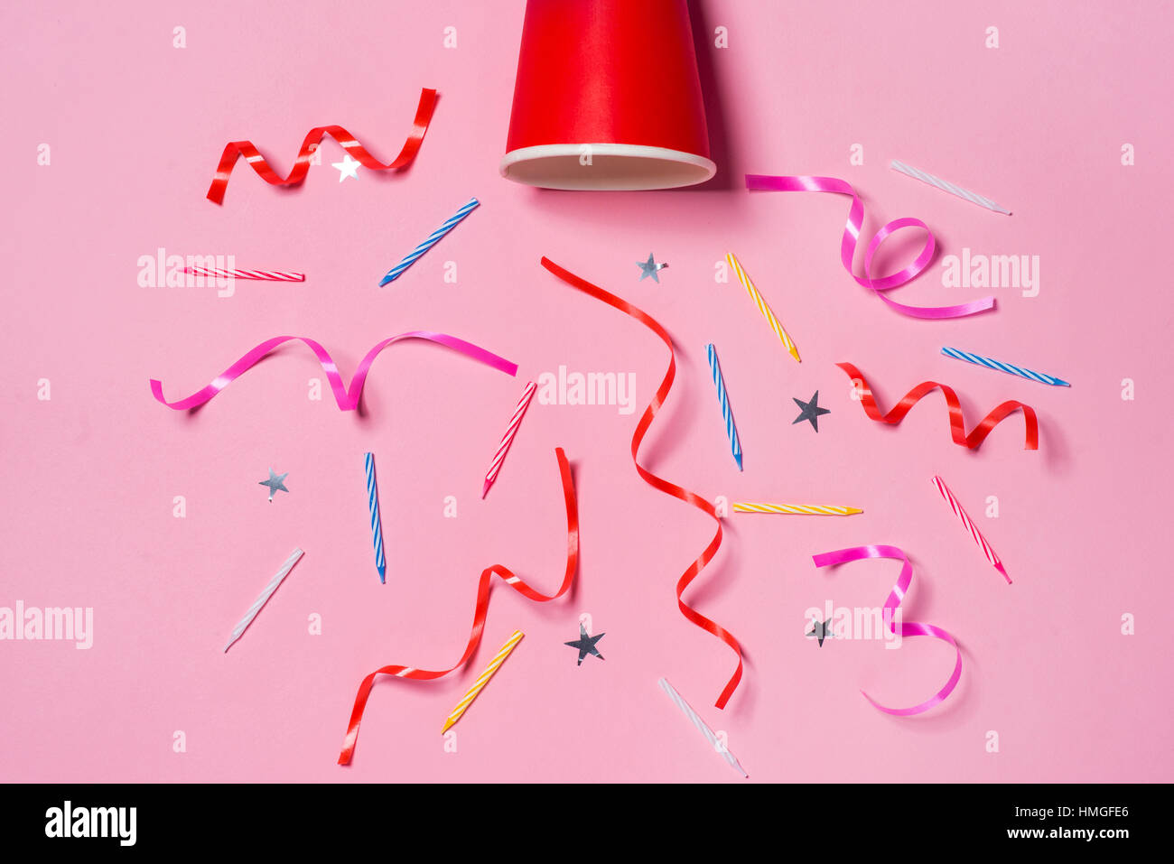 Wohnung lag der Feier. Pappbecher mit bunten Partystromer auf rosa Hintergrund. Stockfoto