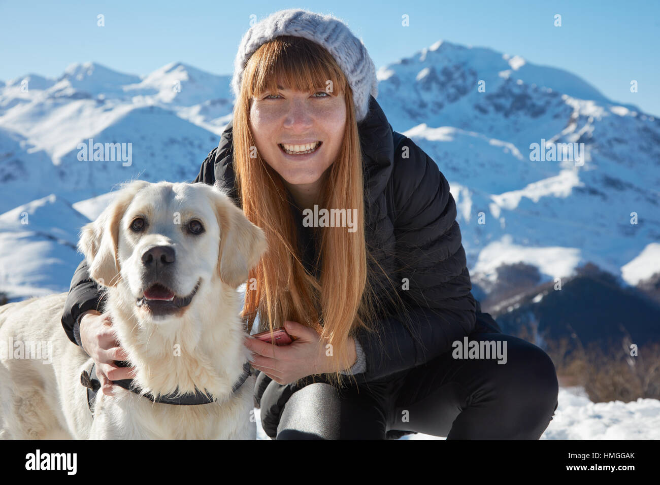 Junge Frau lächelnd mit golden Retriever Haustier Freund in einem sonnigen winter Stockfoto