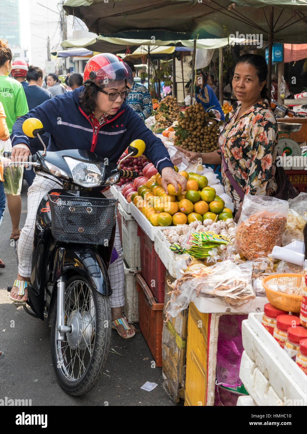Pingelig Motorradfahrer Auswahl Orangen am russischen Markt, Phnom Penh, Kambodscha Stockfoto