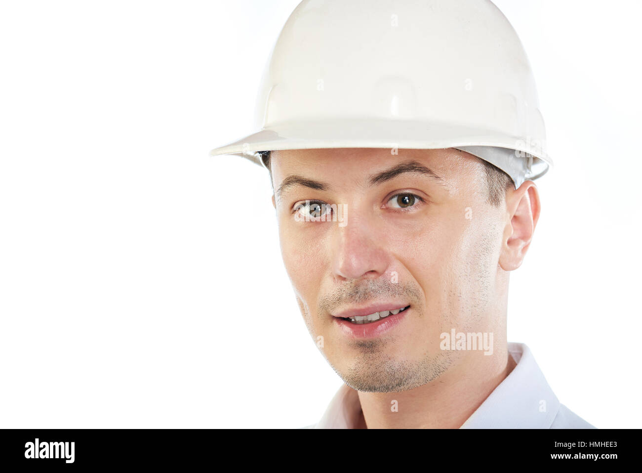 Porträt des jungen Ingenieurs mit Bauarbeiterhelm isoliert auf weiss Stockfoto