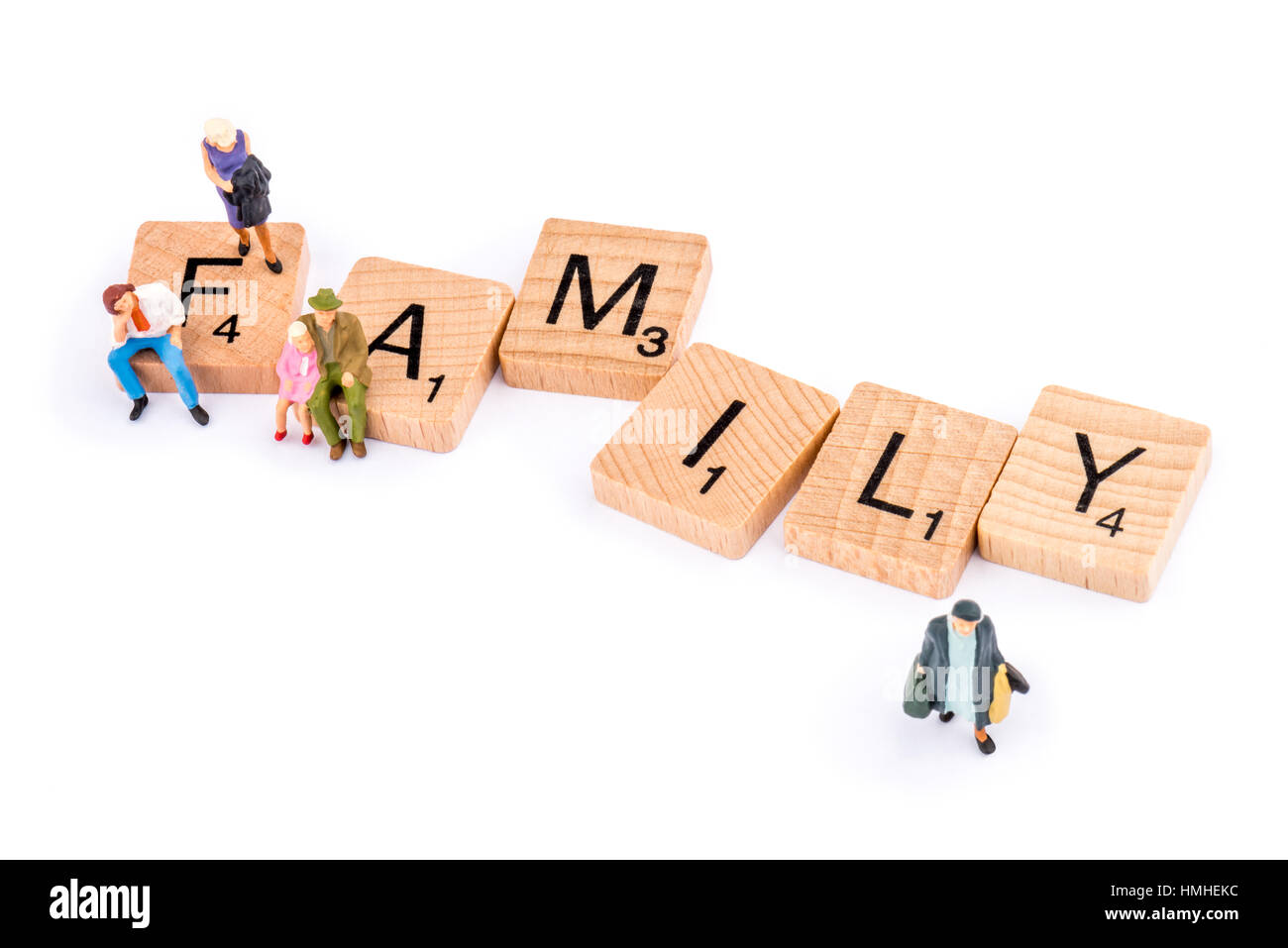 Scrabble Buchstaben bilden das Wort Familie. Zahlen belegen die Buchstaben F und A, während eine ältere Dame Weg von der Buchstabe Y geht. Stockfoto
