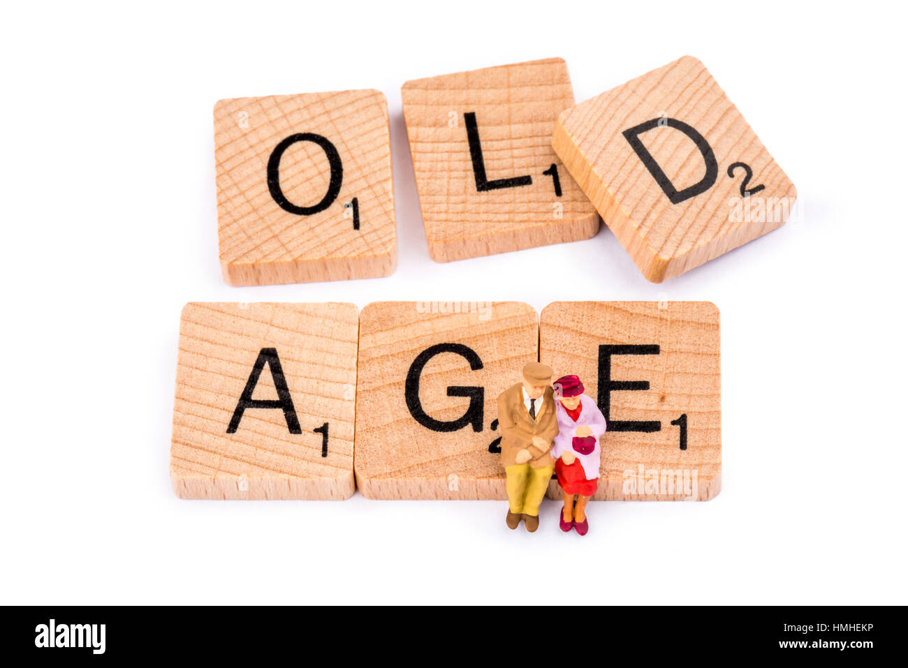 Scrabble Buchstaben bilden das Wort Alter. Ein älteres Ehepaar auf das Wort Alter sitzen. Stockfoto