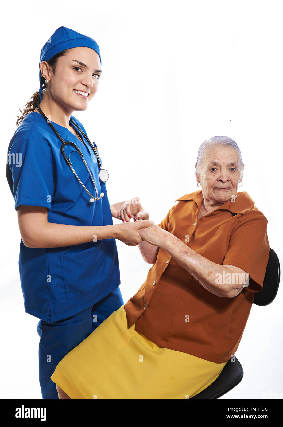 Krankenschwester halten alte Dame die Hände isoliert auf weiss Stockfoto