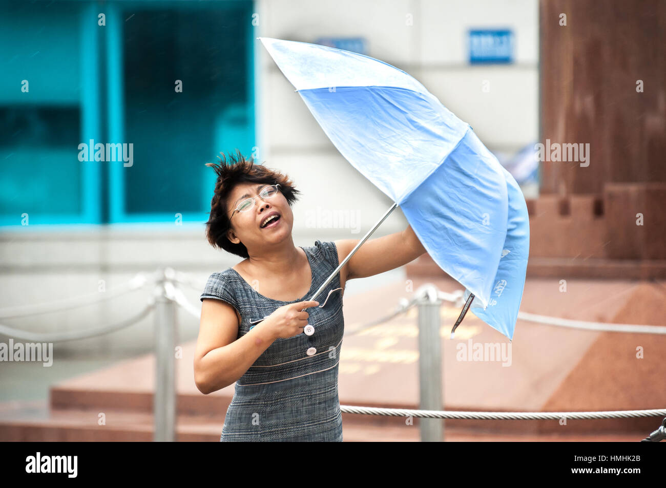 WANCHAI, HONGKONG - Sept. 22, 2013 - ein Chinesischer tourist Kämpfe mit Ihrem Schirm bei starkem Wind wie ein Taifun Ansätze Hong Kong. Stockfoto