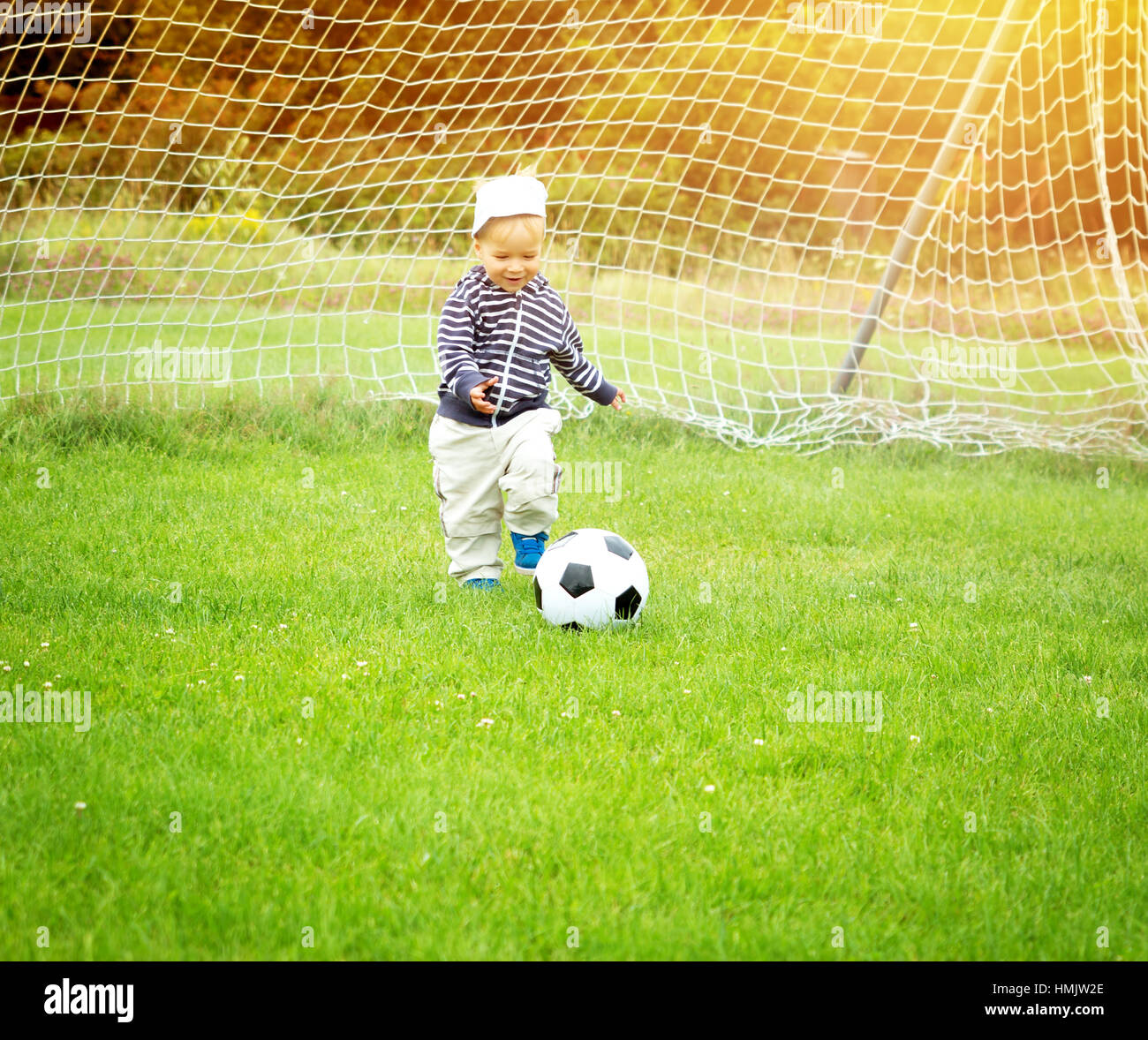 Kleine Jungen spielen Fußball auf dem Spielfeld mit Toren Stockfoto