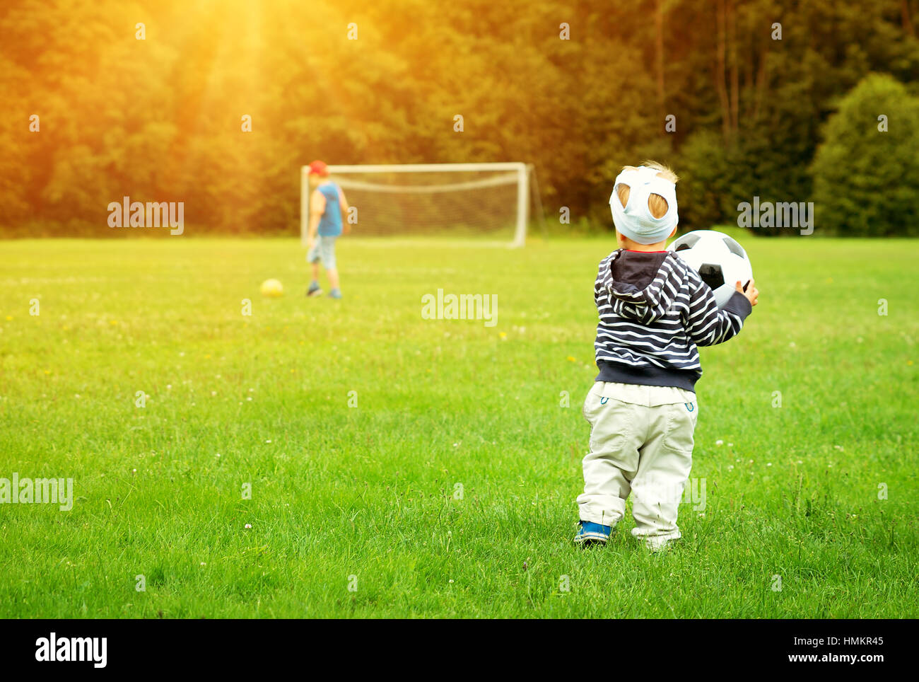 Kleine Jungen spielen Fußball auf dem Spielfeld mit Toren Stockfoto