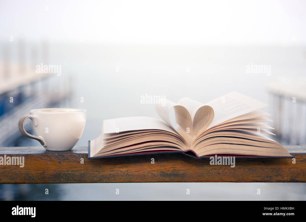 Buch und Kaffee-Zeit auf der Terrasse am Meer Stockfoto