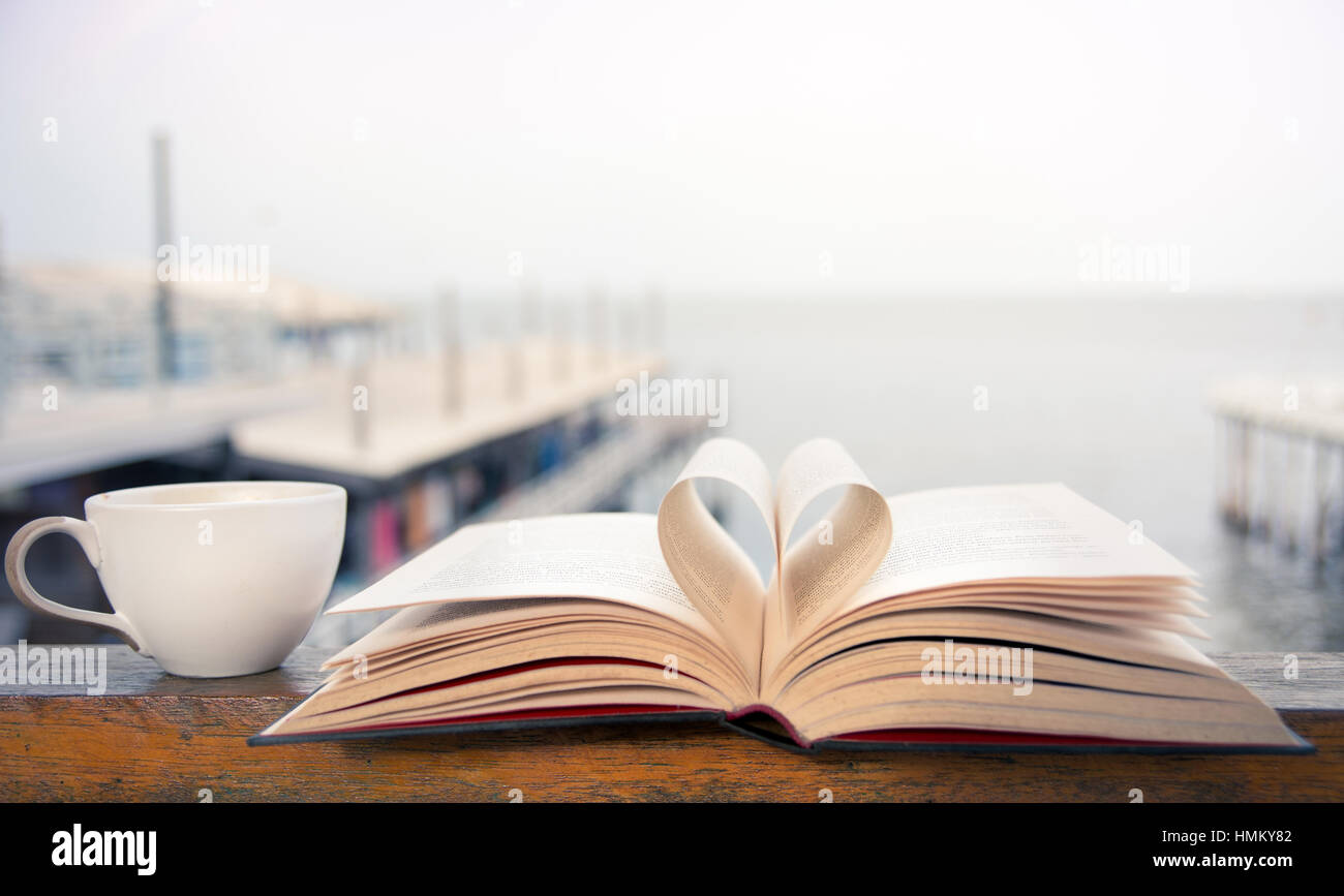 Buch und Kaffee-Zeit auf der Terrasse am Meer Stockfoto