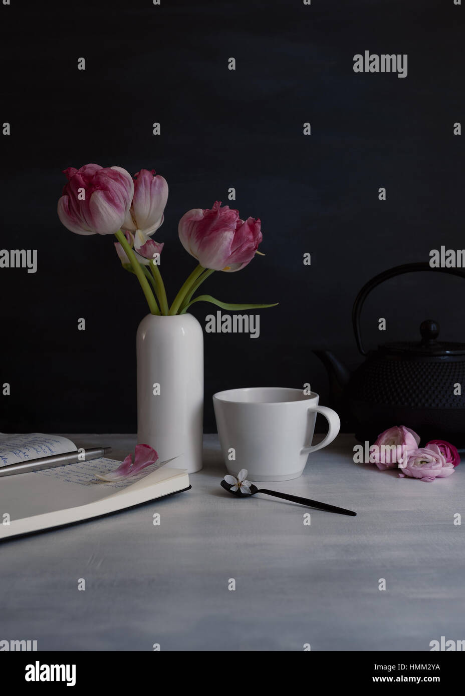 Stillleben mit rosa doppelte Tulpen in weiße kleine Keramik-Vase mit Becher und Löffel, low-key Stockfoto