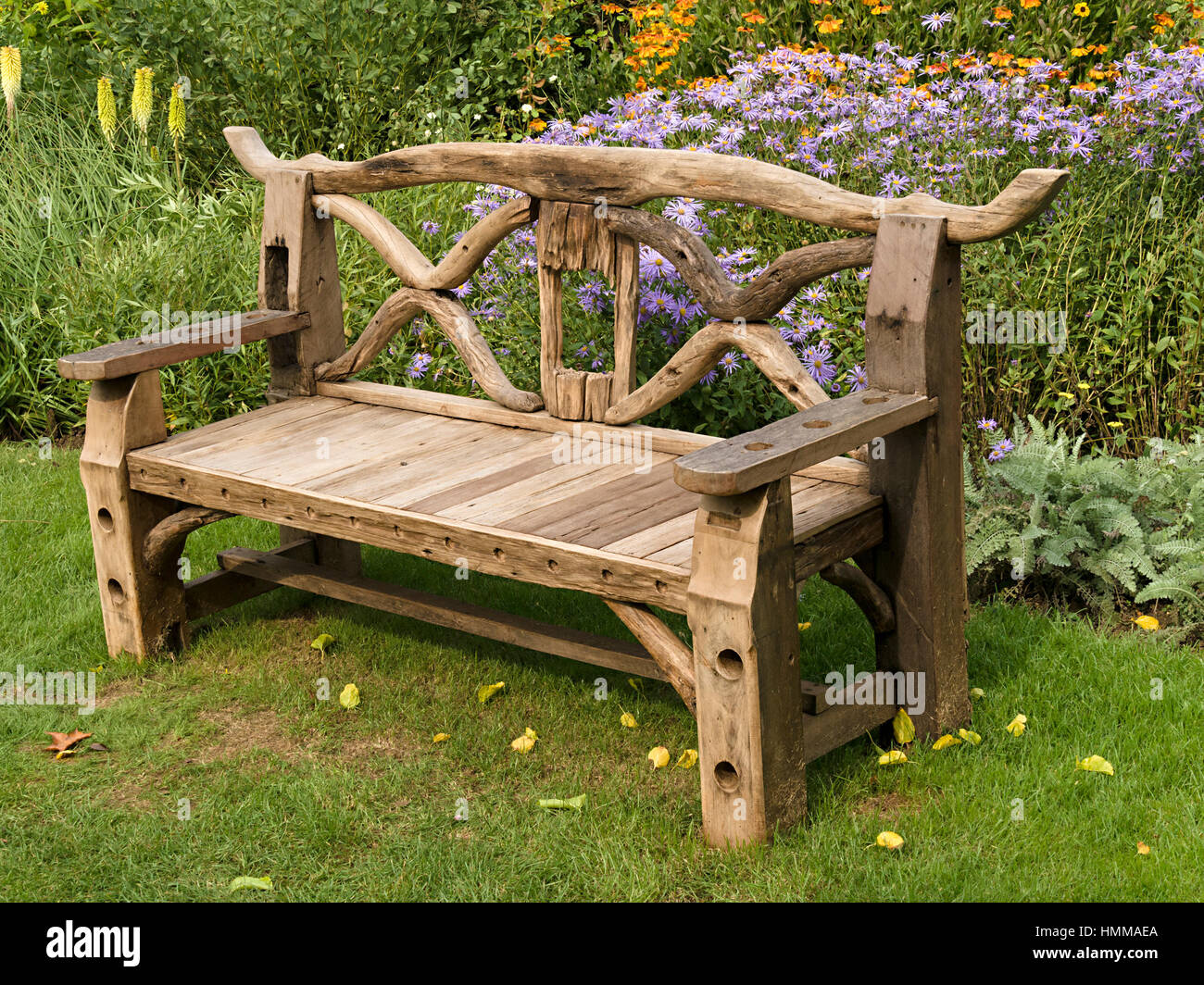 Kunstvolle, rustikal, hölzerne Garten Sitzbank, hergestellt aus recycelten  Holzteile vor unteren Betten, Coton Manor Gardens, Northamptonshire,  England, UK Stockfotografie - Alamy