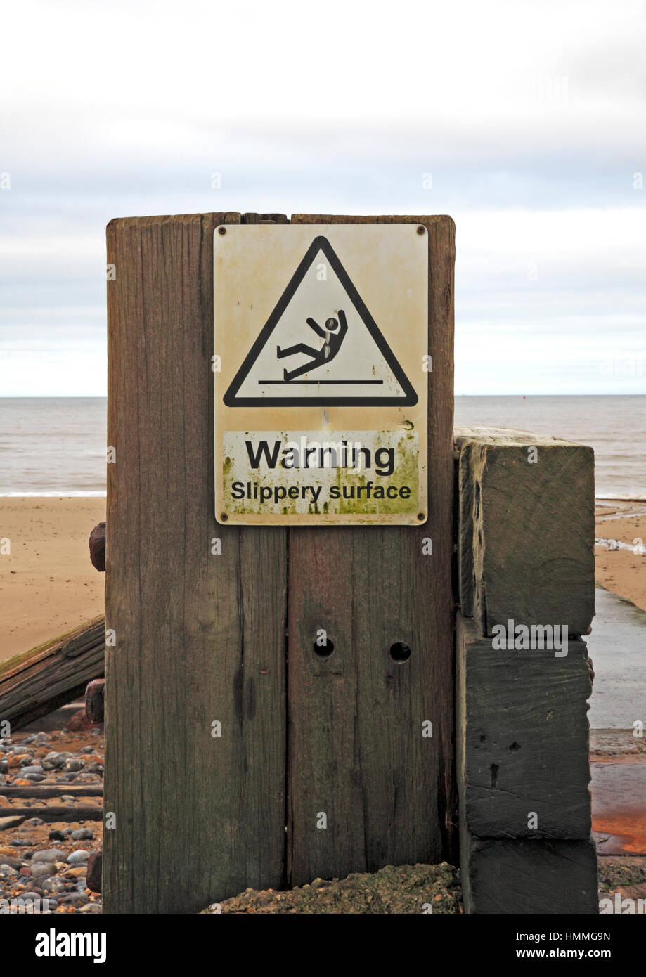 Eine rutschige Oberfläche Warnschild am Strand von Mundesley-on-Sea, Norfolk, England, Vereinigtes Königreich. Stockfoto