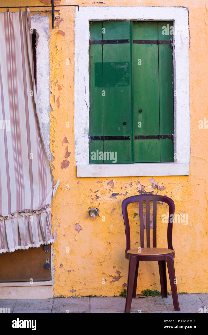 Stuhl und Fensterläden des Hauses in Burano, Venedig, Italien im Januar Stockfoto