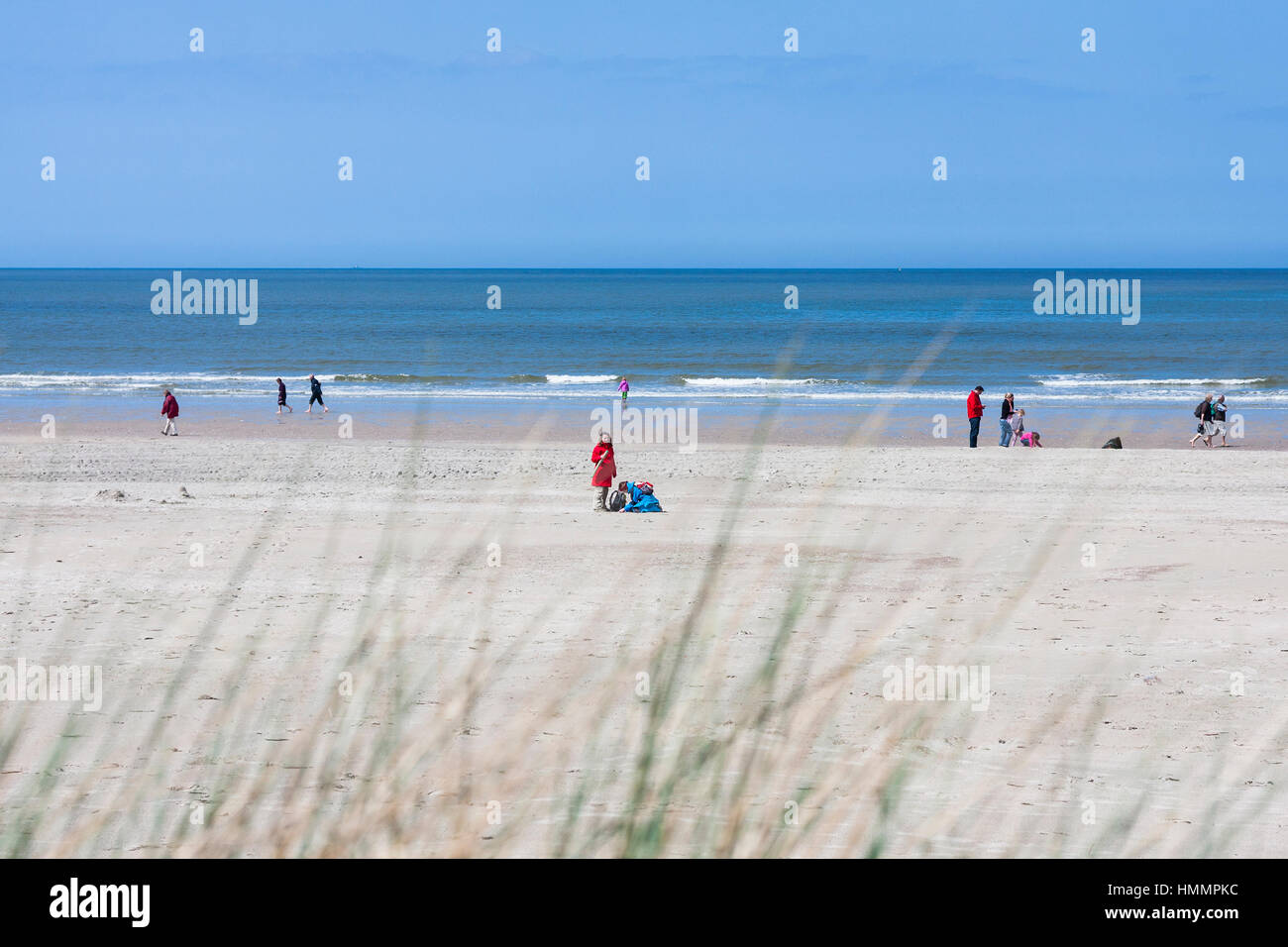 Norderney - Mai 9: Menschen auf dem Strand In Norderney mit einigen Grass in den Vordergrund und Hintergrund auf 10. Mai 2013 im Mittelpunkt Stockfoto