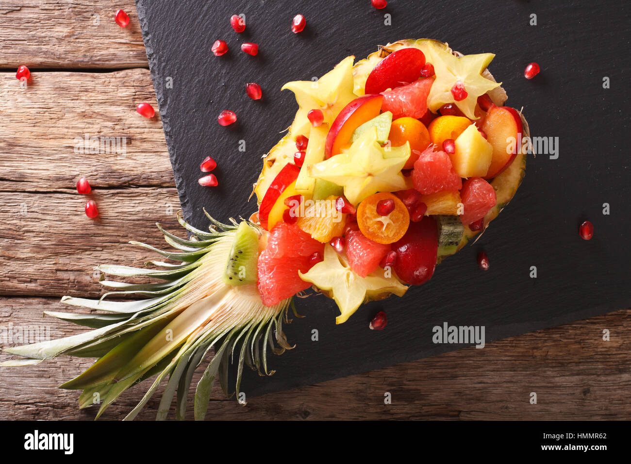 Reifer Ananas gefüllt mit frischen tropischen Früchten Nahaufnahme auf dem Tisch. horizontale Ansicht von oben Stockfoto