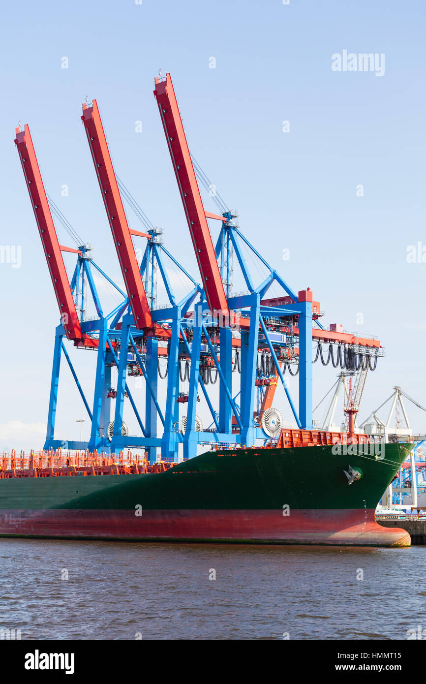 Containerhafen mit hohen Kränen und angedockten Schiff im Hamburger Hafen, Deutschland Stockfoto