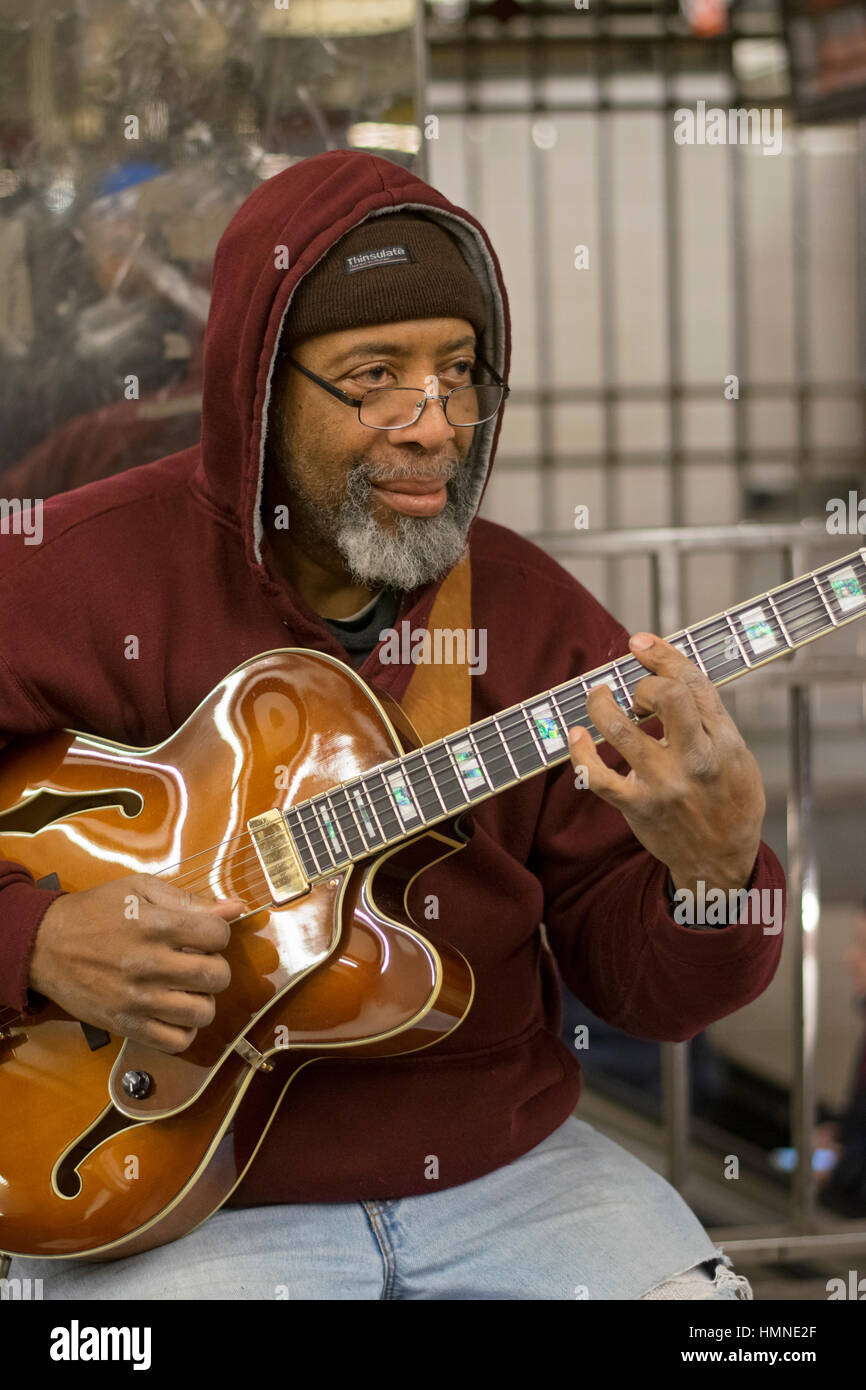 Ein Mann mittleren Alters afroamerikanische spielen die e-Gitarre u bei der u-Bahnstation 34th Street in Manhattan, New York City. Stockfoto