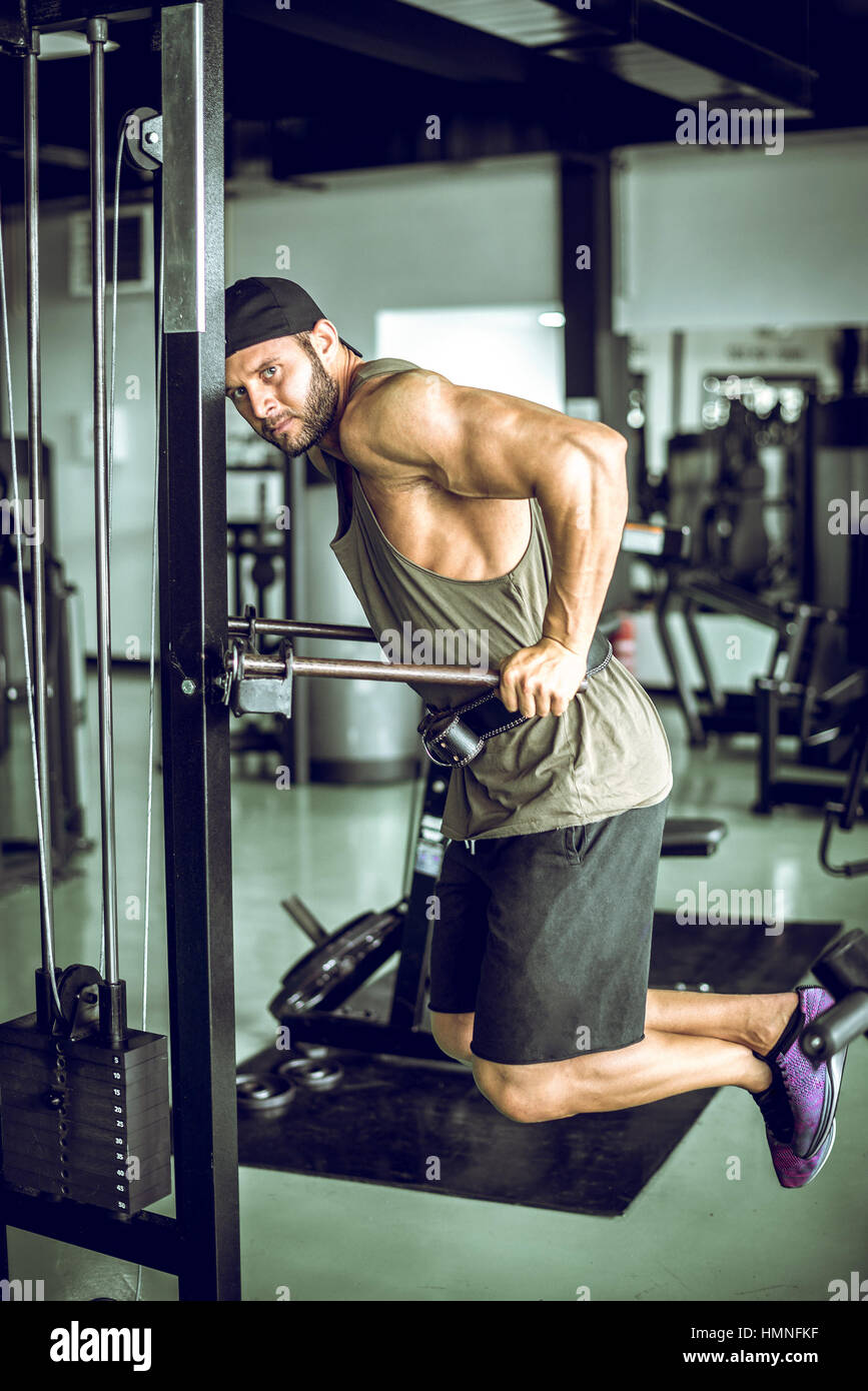 Attraktive junge Erwachsene Mann tut taucht Übung im modernen Fitnesscenter. Durchtrainierten Bild. Stockfoto