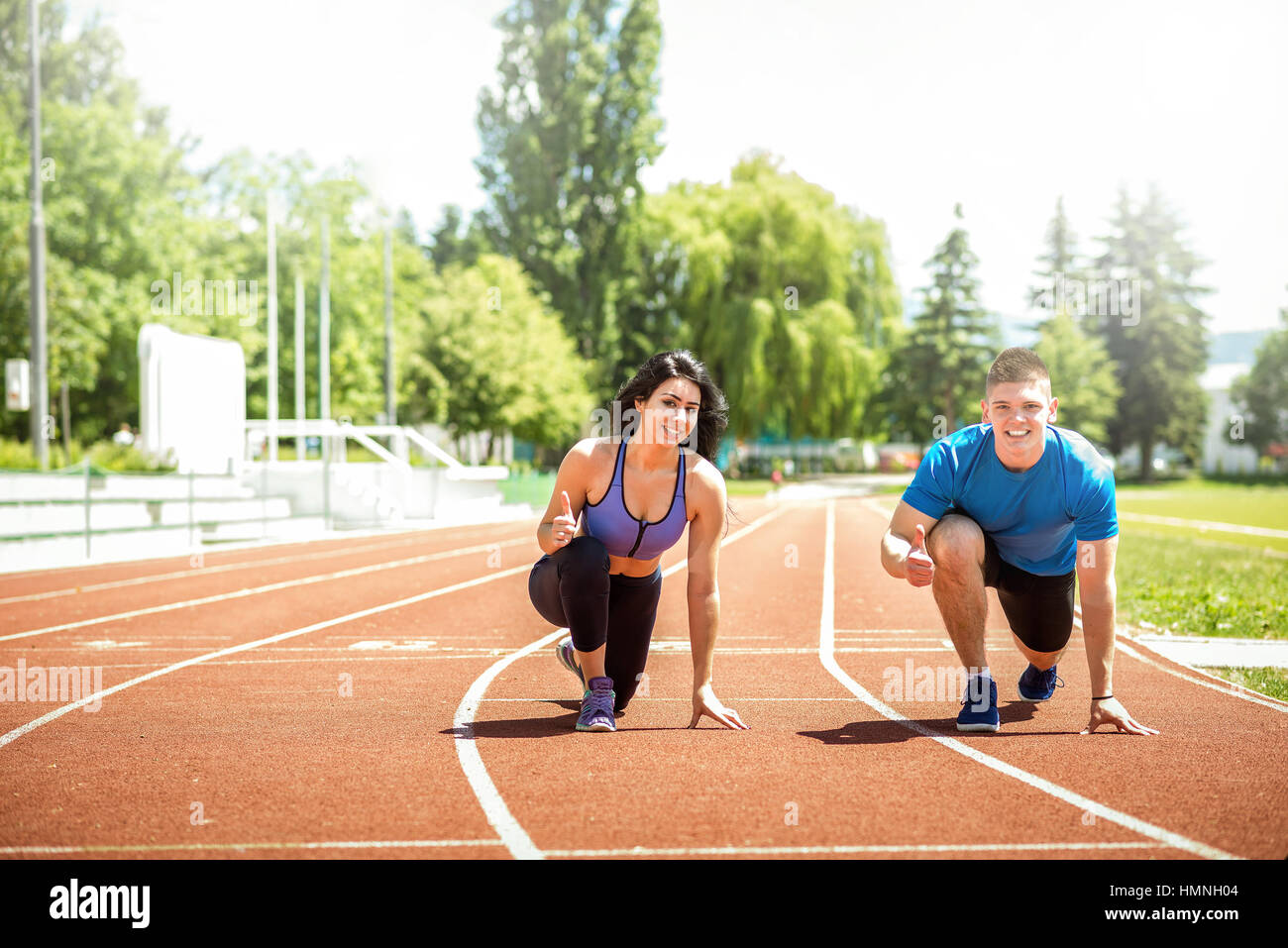 Fitness laufen paar jogging auf Leichtathletik-Stadion Track Open-Air an heißen Sommertag. Wettbewerb-Konzept. Unterstützung. Durchtrainierten Bild. Stockfoto