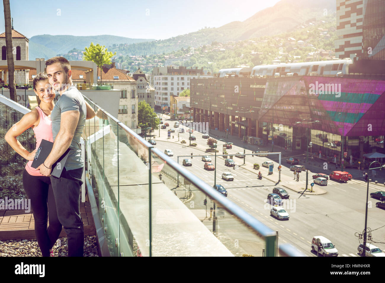 Jungen Erwachsenen weiblichen Fitness Model posiert auf Dachterrasse mit ihrem persönlichen Trainer anschließend Fitness-Übungen. Stockfoto