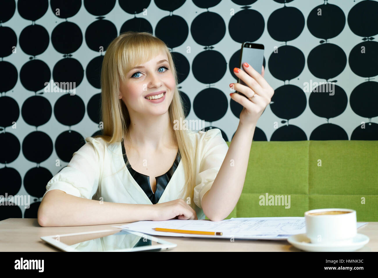 Mädchen sitzen im Café hält ein Mobiltelefon Stockfoto