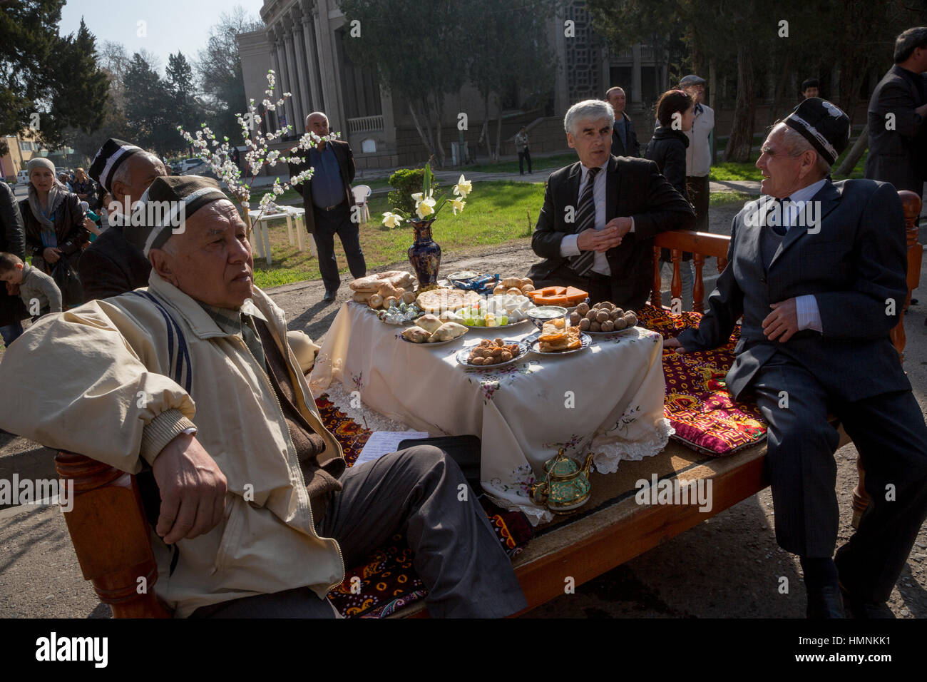 Männer sitzen an den traditionellen festlich gedeckten Tisch während der Feier von Nowruz in der Mitte von Khujand in Sughd Provinz von Tadschikistan Stockfoto