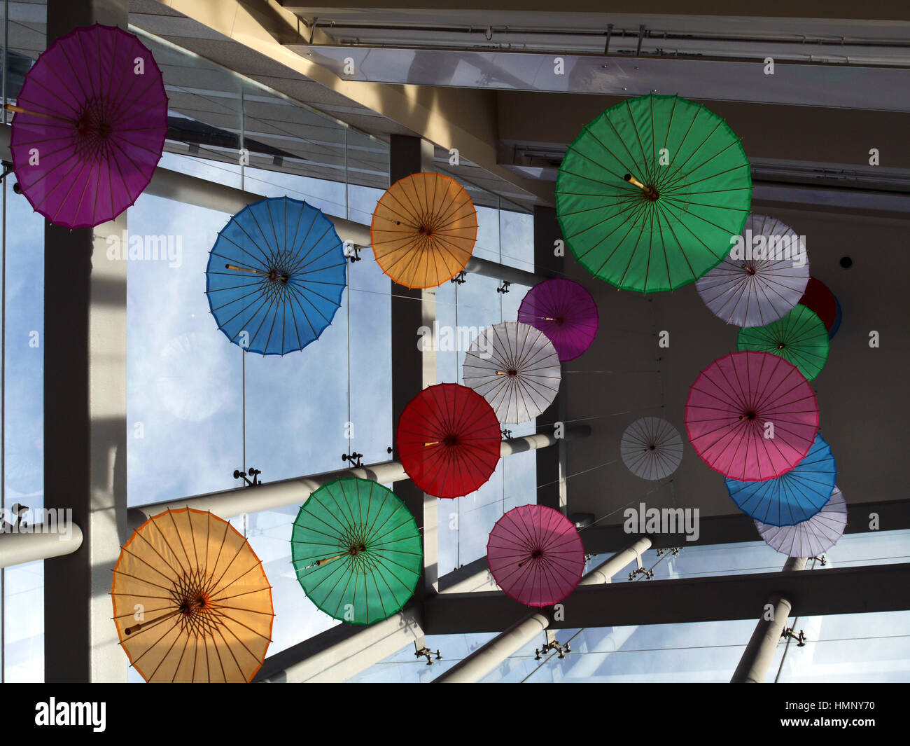 Farbige Sonnenschirme ausgesetzt von der Decke einer Mall in der Spülung Abschnitt von New York City, im Stadtteil Queens. Die Gegend ist überwiegend ein Stockfoto
