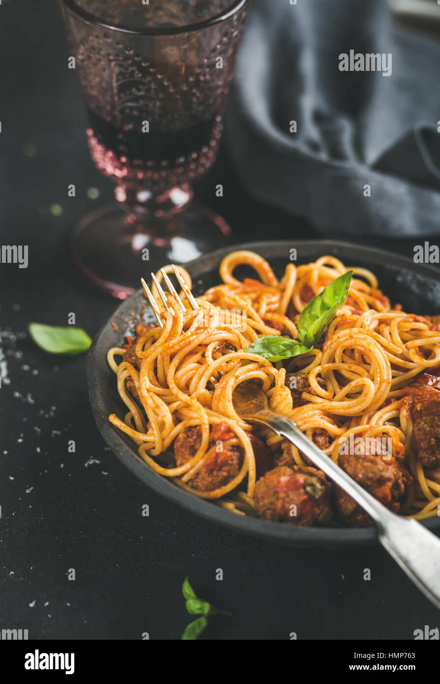 Spaghetti mit Meatballas, frische Basilikumblätter und Rotwein Stockfoto