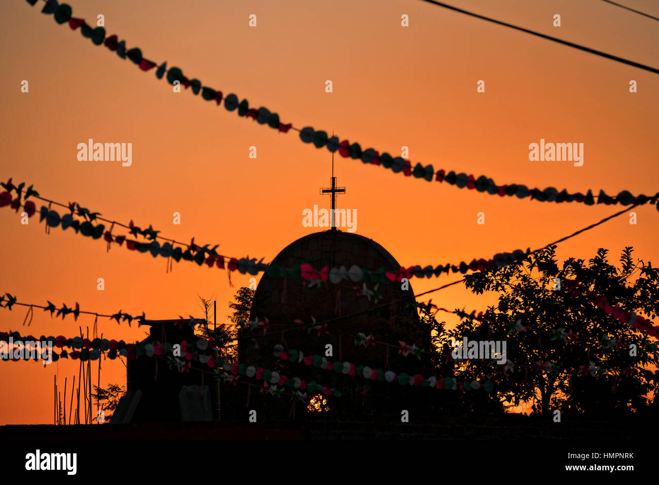 Sonnenuntergang über einer Kirche an einer Haltestelle Dorf entlang der Straße während der jährlichen Wallfahrt Cabalgata de Cristo Rey 4. Januar 2017 in La Sauceda, Guanajuato, Mexiko. Tausende von mexikanischen Cowboys und Pferd beteiligen sich die drei-Tages-Fahrt zum Berggipfel Schrein des Cristo Rey stoppen auf dem Weg an Schreinen und Kirchen. Stockfoto