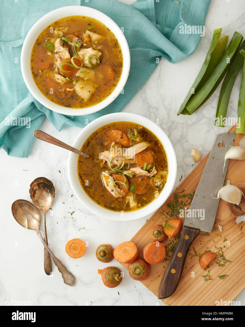 Truthahn oder Huhn Reis-Gemüse-Suppe in zwei weißen Schalen serviert. Ein Schneidebrett, Messer und die Reste aus gehacktem Gemüse haben über verstreut worden Stockfoto