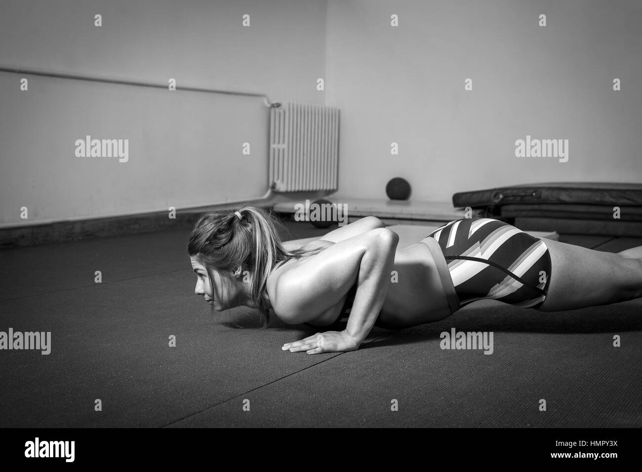 Junge Erwachsene Mädchen Push Ups trainieren im Fitness-Studio Stockfoto