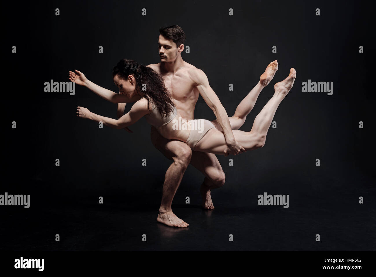 Leistungsstarke junge Sportler, die vor der schwarzen Wand Stockfoto