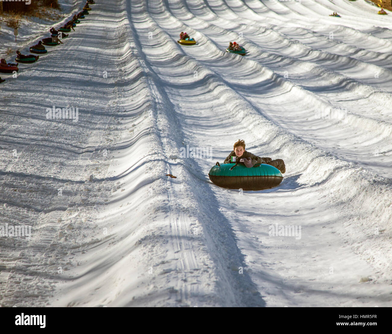 Snowtubing einen Hügel hinunter Stockfoto