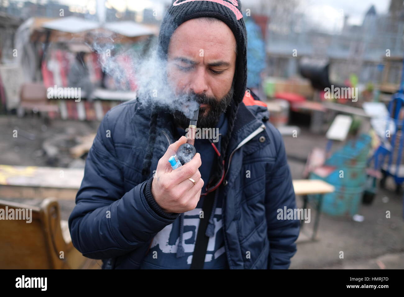 Mann hält und raucht Pfeife Stockfoto